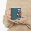 a halloween themed coffee mug which a lady is holding in her hand to show how easily the mug can be held and also not very big in size, the mug has unique design on the halloween theme